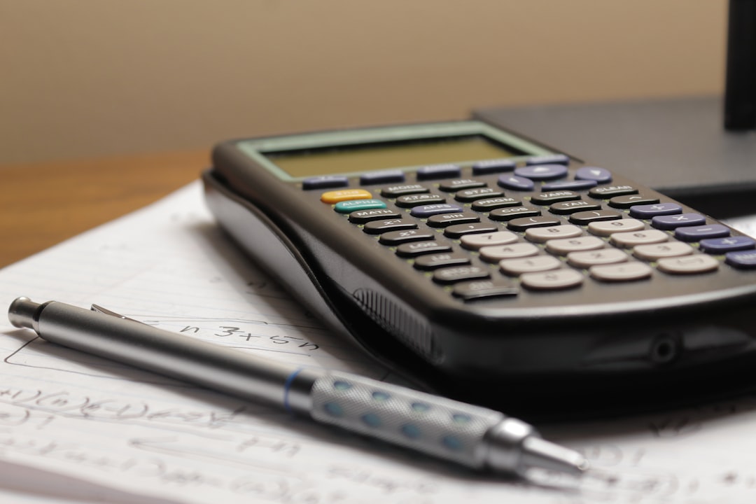 services-04 a-calculator-and-a-pen-sitting-on-top-of-a-piece-of-paper-vs6ip7fsld8