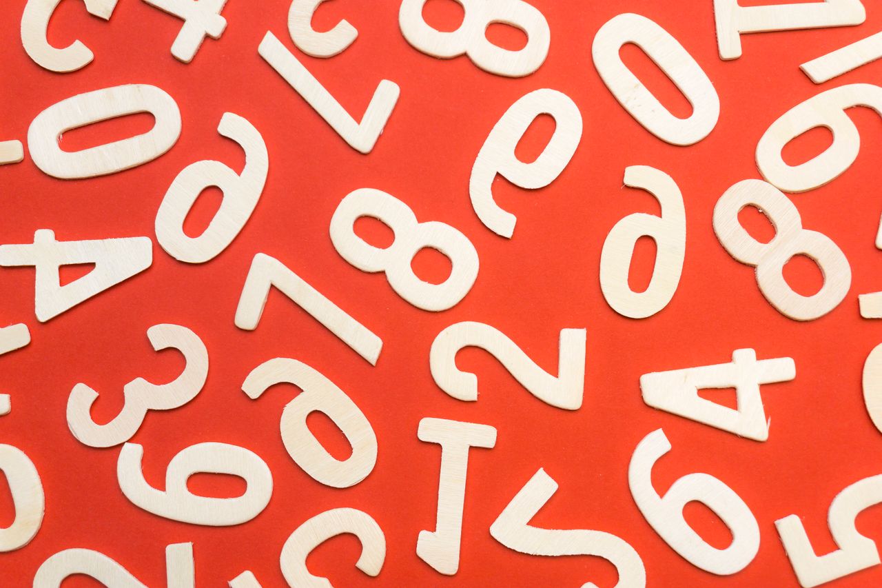 why-choose-us Abstract flat lay of white numbers on red background.